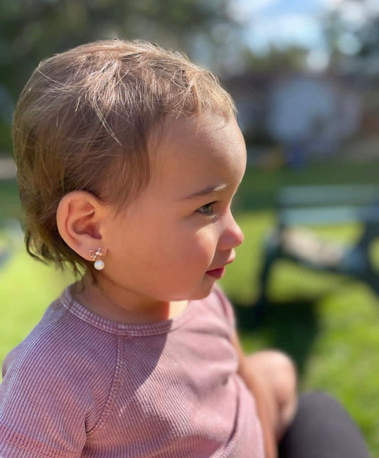 child wearing 14k gold bow pearl screw back earrings