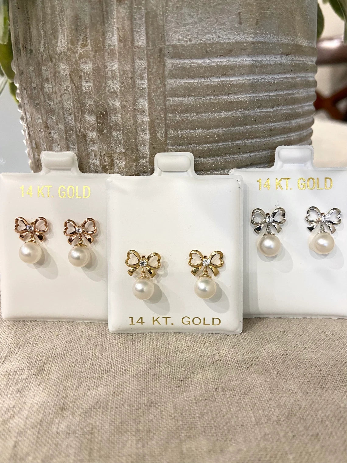 14k gold bow earrings with hanging pearl close up